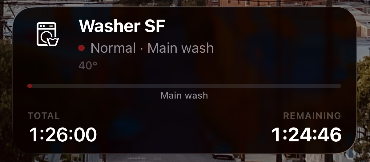 Live Update card on the iPhone Lock Screen: Washer SF, Normal, Main wash at 40°, total 1:26:00, remaining 1:24:46.